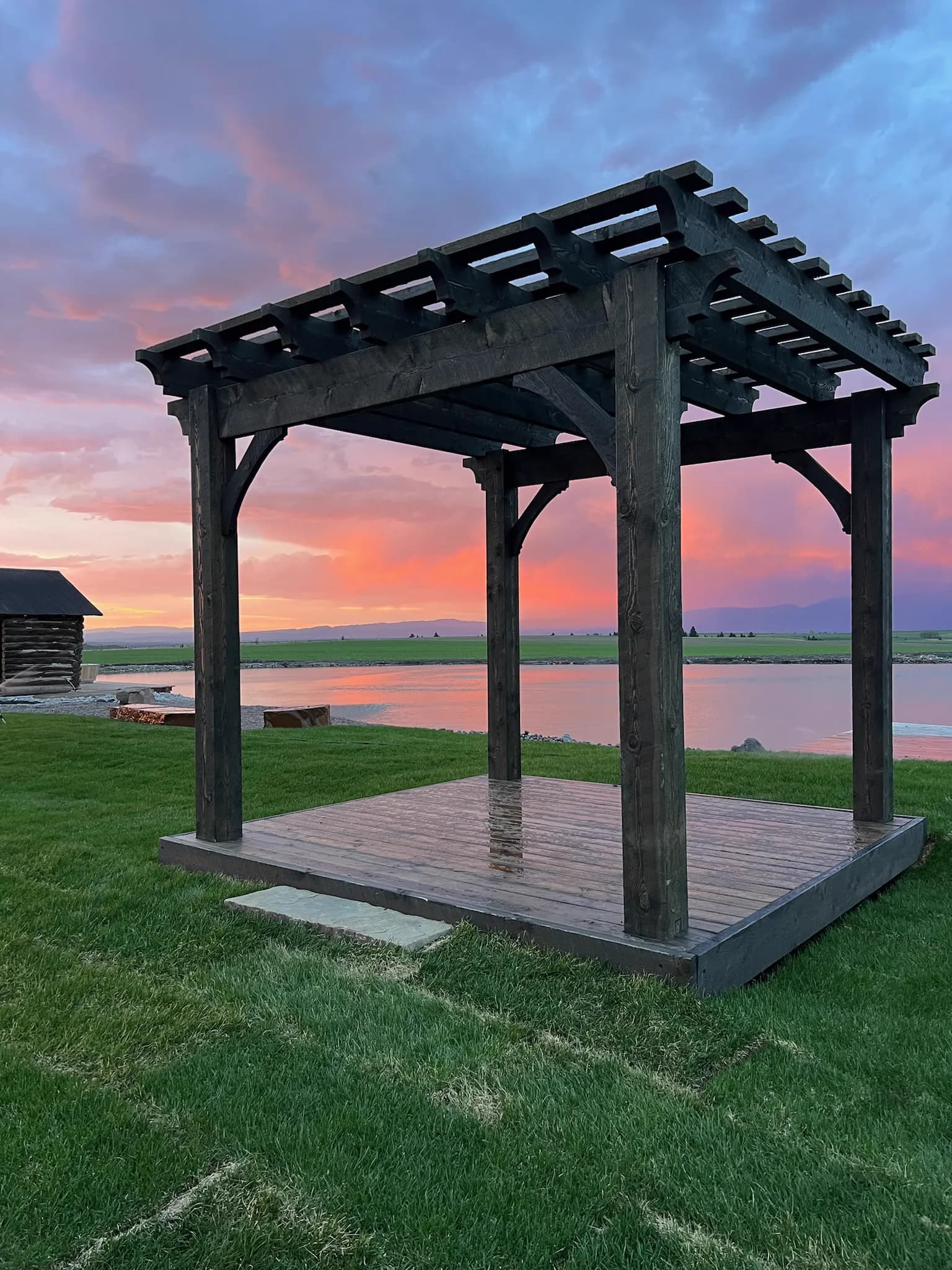 Wooden pergola structure by the lake at sunset at Big Vista Ranch